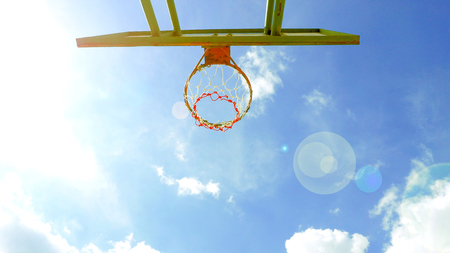 Basketball hoop background blue sky and sunshine have lens flare nice photo.の写真素材