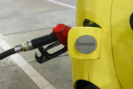 Nozzle fuel Gasohol 95 serving in to small car yellow color, The door cover has sticker sign silver danger word.の写真素材