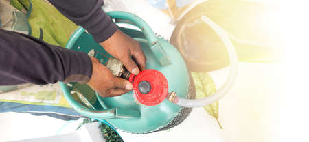 Demon shot service man to showing how to change Gas LPG tank 15 kilogram, At his hand is valve to disassemble to separate.の写真素材