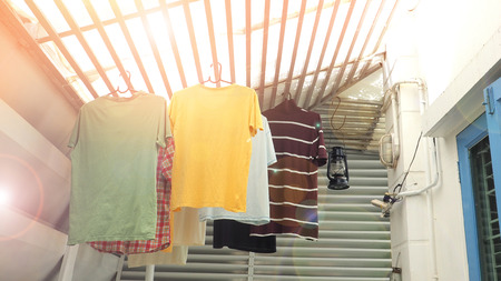 Hang the clothes are t-shirt hanging on the roof batten under the sun in my house.