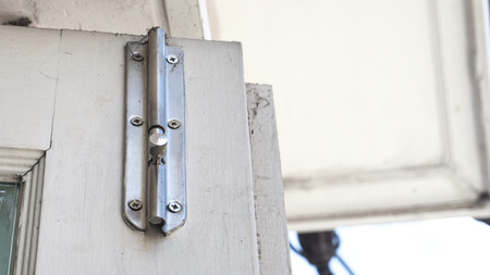 Stainless still Latch on the door has copy space roof white color at terrace of house.