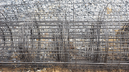Wire mesh rolled steel grille material in the site on gravel and sand background construction.