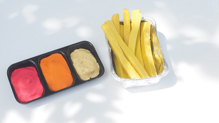 French fries in foil packaging and 3 dipping sauce are tomato, chili, salad cream, mayonnaise is on...