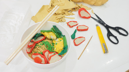 Egg noodle with dumpling, pork red sauce, vegetable molding clay of creativity activity hobbies, Macro photo focus select in bowl around are blur has equipment cutter, scissor close up see the detail isolate on white.の写真素材