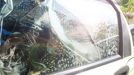 Step 5 wrap, stick a film car and spray a shampoo and air bubbles for keep a film firmly in glass window service industries, Lens fare photography.の写真素材