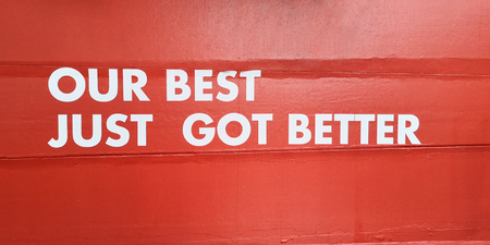 Our best just got better sticker di-cut white word sign on cement concrete red wall to guarantees the commitments with customer in service industry shop or company.の写真素材