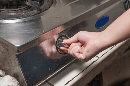 a hand operating the gas stoveの写真素材