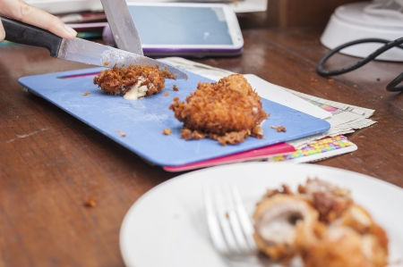 cutting fried pork with knifeの写真素材
