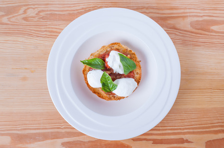 pie with cream cheese, red sauce and basil on wood tableの写真素材