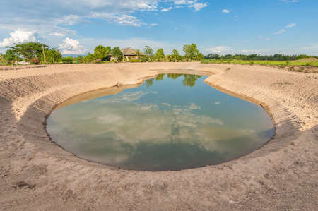 agriculture pond in dried field.の写真素材