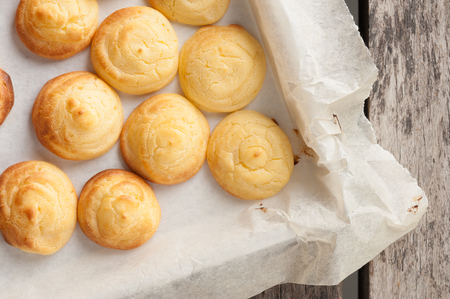 Choux cream in bakery tray on wood table.