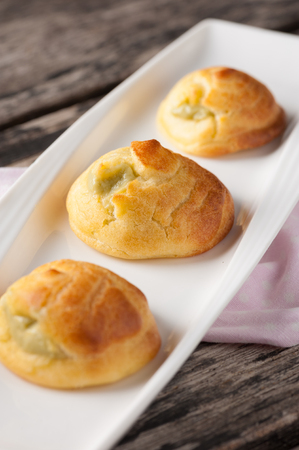 Green tea choux cream on wood table.
