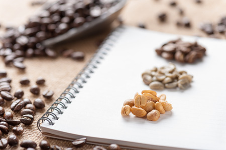 Coffee beans with notebook on sackcloth.の写真素材