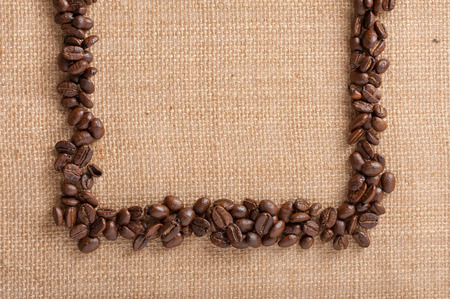 Coffee beans as a frame on sackcloth.の写真素材