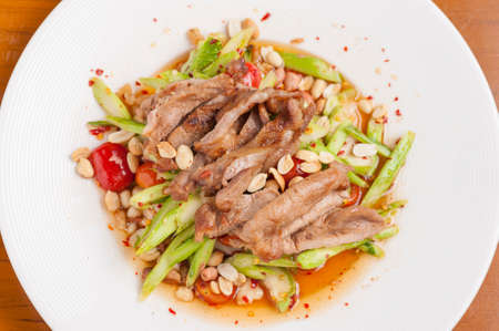 Thai style spicy salad with grilled pork and kale.の写真素材