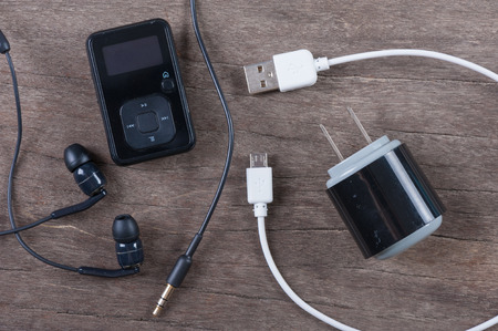 Portable music player with earphone and cable on wooden backgroundの写真素材