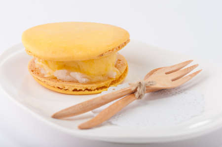 Yellow macaroon shell sandwich with ice cream and sticky riceの写真素材