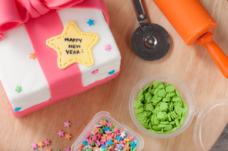 New year present concept fodant cake on wood table.の写真素材