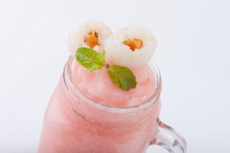 Lychee smoothie with pieces of lychee on white tableの写真素材