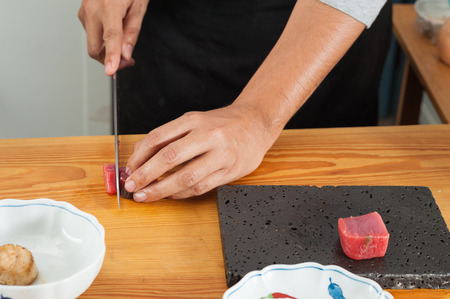 A chef cutting Akami (tuna) in kitchenの写真素材