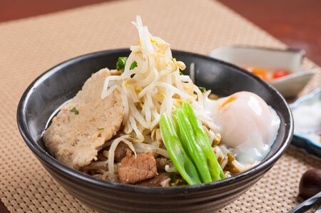 Japanese noodle  with Thai spicy soup, pork and onsen egg.の写真素材