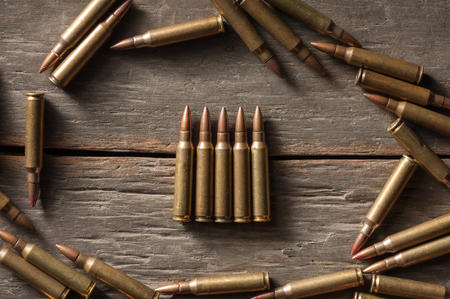 Rifle bullets on wood table with low key sceneの写真素材