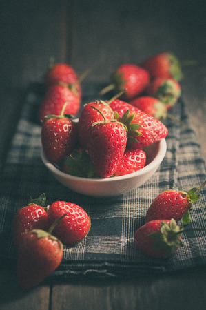 Strawberries on wood in vintage style with film filter effectの写真素材