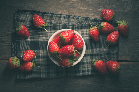 Strawberries on wood in vintage style with film filter effectの写真素材