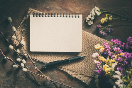 Small notepad with pen on rustic wood with film filter effectの写真素材
