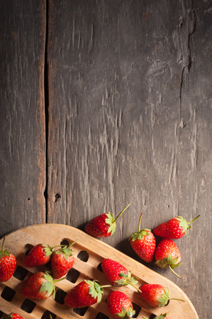 Strawberries on wood background in vintage style with low key scene.の写真素材