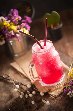 Red frozen cocktail on wood table in vintage style with low key sceneの写真素材