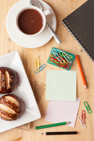 Notebook and sticky paper, paper clip, color pencil, and pen on wood table in vintage styleの写真素材