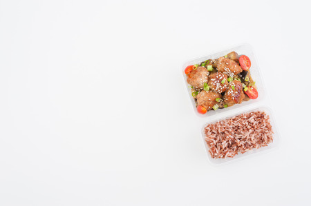 Tsukune (Japanese chicken meatballs) cooked by clean food concept with brown rice in lunch box on white tableの写真素材