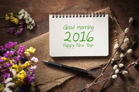 "Good morning 2016 Happy new year" is written on small notepad with pen on rustic wood background with low key scene.の写真素材
