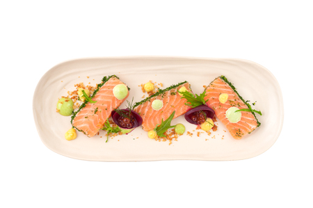 Smoked salmon with herbs, beetroot, faked salmon roe (sauce cooked by molecular gastronomy technic) garnished with mago sauce and wasabi mayo isolated on white background with clipping pathの写真素材