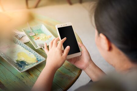 Young woman using smartphone for social networking in cafe on weekend. Trendy lifestyle concept with technology.の写真素材