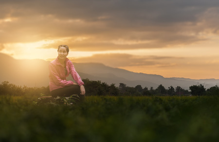 Vacation lifestyle scene of woman wearing sport cloths sitting on rocks with nature view in blurry background in morning time. Woman activity on holiday conceptの写真素材