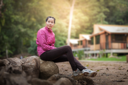 Vacation lifestyle scene of woman wearing sport cloths sitting in park and enjoy with nature in morning time. Woman activity on holiday concept.の写真素材