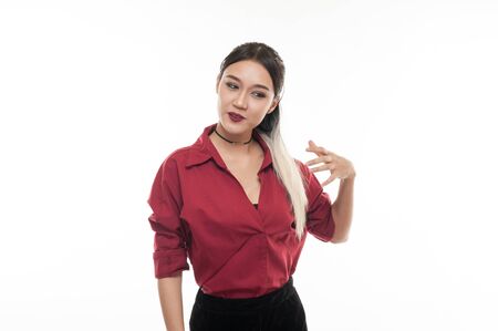 Young attractive tan skin Asian woman wear red shirt in good feeling action. Studio scene of woman with positive emotion with copy spaceの写真素材