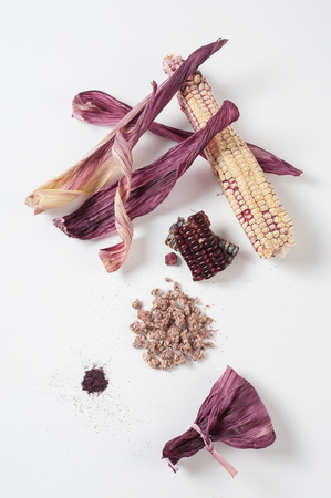 Black glutinous corn components on white table including kernels,  dried peels, feather powder and...