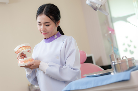 Female dentist explain about brushing teeth in clinic. Health care and maintenance with expert conceptの写真素材