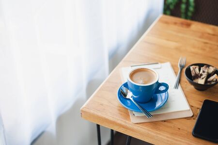 Abstract emotional scene of hot Long black (Americano) in blue coffee cup on table at cafe in morning time.の写真素材