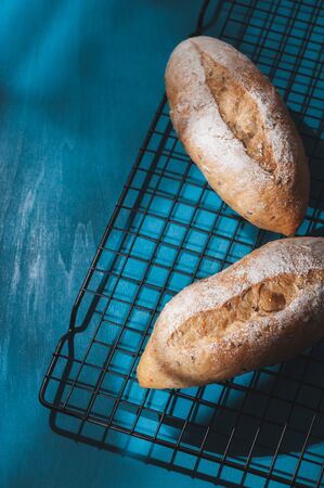 Baguette, European style bread on blue wood table in morning time with hard light effect.の写真素材
