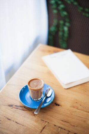 Abstract emotional scene of hot Piccolo latte in small coffee glass on table at cafe in morning time.の写真素材