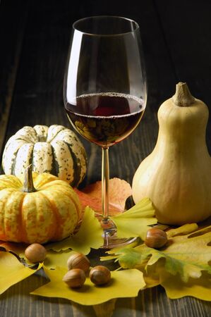 Autumn theme; pumpkins, leaves and hazelnuts on rustic surfaceの写真素材