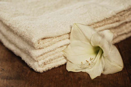 Beauty arrangement, towels with white flower and some beauty products on wooden table, selective focusの写真素材