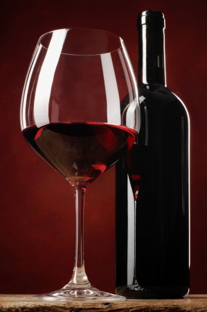 glass of red wine and bottle on a tableの写真素材