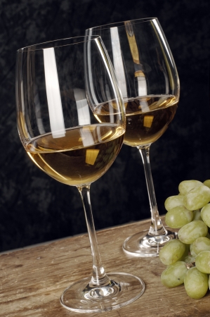 two glasses of white wine with grapes の写真素材