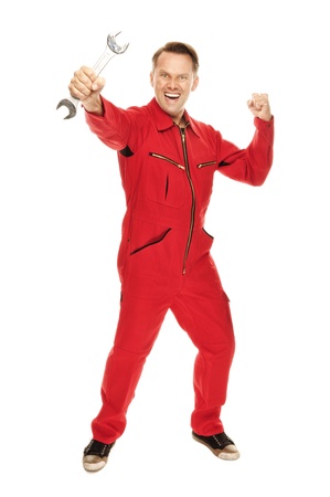 Mechanic in red Overall holding a screw-wrench in his hand and making a powerful gesture, isolated on whiteの写真素材