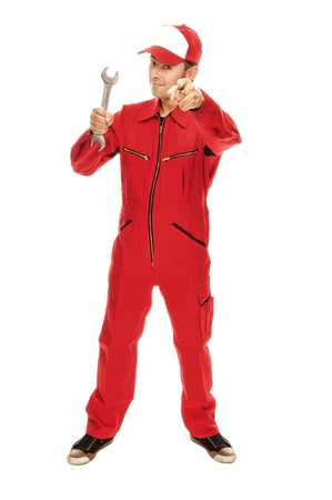 Mechanic in red Overall pointing at camera and holding a wrench, isolated on whiteの写真素材